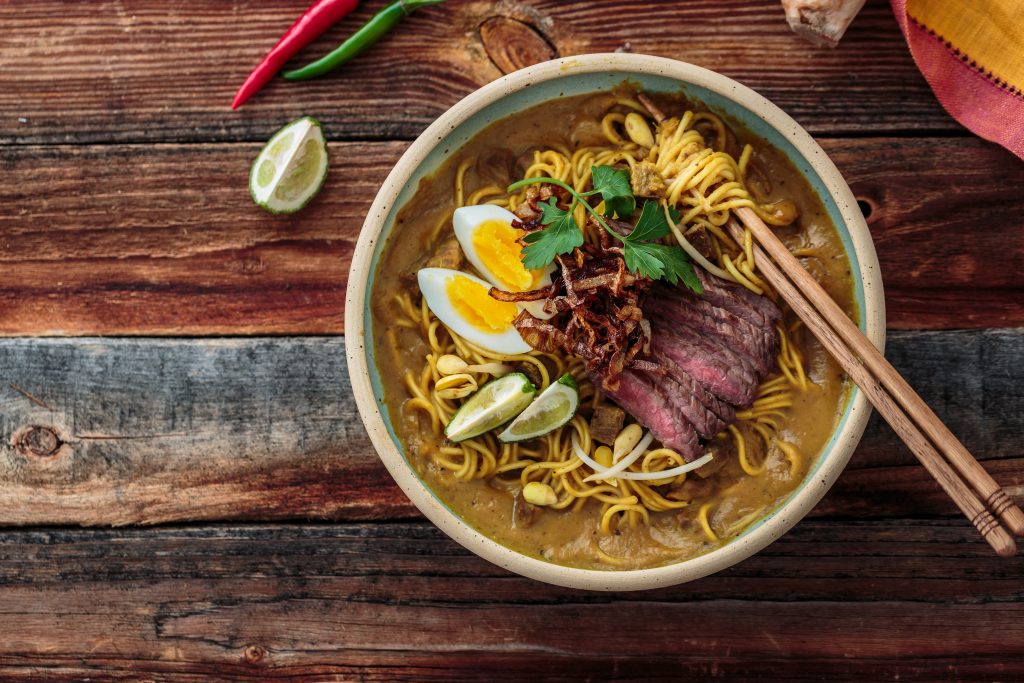 Boiled noodles, beef steak, egg, onion in a bowl, asian cuisine,